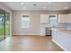 Bright and airy kitchen features white cabinets, stainless steel appliances, and a breakfast bar with easy access to the backyard at 5333 Sw 81St Cir, Ocala, FL 34481