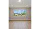 Bright living room with wood-look flooring and a large window overlooking the backyard at 5333 Sw 81St Cir, Ocala, FL 34481