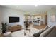 Bright open-concept living room features a modern TV console and stylish decor with seamless access to the kitchen and dining area at 5333 Sw 81St Cir, Ocala, FL 34481