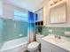Bathroom with a shower-tub, a blue-themed shower curtain, and under-sink storage at 1625 Crystal E Ct, Lakeland, FL 33801