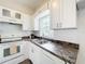 Functional kitchen with white cabinets, dark countertops, and a window offering natural light at 1625 Crystal E Ct, Lakeland, FL 33801