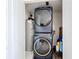 Efficient laundry room with a stacked washer and dryer and a hot water tank at 1625 Crystal E Ct, Lakeland, FL 33801