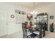 Elegant dining room with a modern chandelier, a large glass table with six chairs, and stylish decor at 1654 Indigo Ave, The Villages, FL 32162