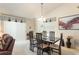 Elegant dining area featuring a modern table set, bright lighting, and seamless access to the living area at 1654 Indigo Ave, The Villages, FL 32162