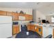 Charming kitchen featuring wooden cabinets and modern white appliances at 1654 Indigo Ave, The Villages, FL 32162