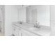 Bright bathroom featuring double sinks, white cabinetry and a large mirror at 5224 Stone Ridge Pl, St Cloud, FL 34771