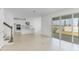 Open floor plan showcases a modern kitchen, living space, staircase, tile floor and sliding glass doors at 5224 Stone Ridge Pl, St Cloud, FL 34771