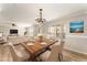 Dining area with a chandelier over a wood table, complemented by views into the living room and natural light at 5331 River Rock Rd, Lakeland, FL 33809