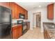 Functional kitchen with ample counter space, black appliances, tile flooring, and cherry wood cabinets at 5331 River Rock Rd, Lakeland, FL 33809