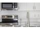 Close up on a stainless steel stove, faucet, sink and microwave in a white and grey kitchen at 2072 Rosewood Cir, Lakeland, FL 33810