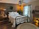 Comfortable bedroom featuring a wooden accent wall, stylish lighting, and a cozy round rug at 1565 Hancock St, The Villages, FL 32162