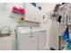 Bright laundry room featuring a modern washer and dryer, sink, storage cabinets, and decorative shelving at 4763 Riverwalk Dr, St Cloud, FL 34771