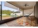 Inviting screened patio with a colorful rug, comfortable seating, ceiling fan, and views of the manicured backyard at 4763 Riverwalk Dr, St Cloud, FL 34771