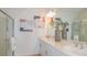 Bright bathroom with double sinks, vanity, decorative mirror, and glass-enclosed shower at 1931 Rosewood Cir, Lakeland, FL 33810