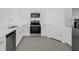 Modern kitchen with stainless steel appliances, white cabinets, and gray tile flooring at 1931 Rosewood Cir, Lakeland, FL 33810