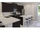 Modern kitchen with stainless steel appliances, a kitchen island, and dark cabinets at 2577 Cotton Candy Aly, Kissimmee, FL 34744