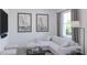 Bright living room with a comfy sofa, stylish decor, and large windows overlooking the outdoors at 2577 Cotton Candy Aly, Kissimmee, FL 34744