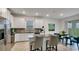 Bright kitchen with stainless steel appliances, white cabinets, and a view into the open concept dining space at 4208 Nightcaps Way, Kissimmee, FL 34746