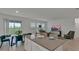 Bright living room with stainless steel appliances, white cabinets, and a view into the open concept dining space at 4208 Nightcaps Way, Kissimmee, FL 34746