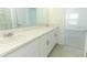 The bathroom has double sinks and white cabinets at 4532 Ranunculus St, Lake Hamilton, FL 33851