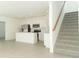 Open-concept kitchen and staircase, complete with white cabinetry and modern stainless steel appliances at 4532 Ranunculus St, Lake Hamilton, FL 33851