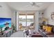 Bright living room with a waterfront balcony view, featuring a modern TV, stylish furniture, and an inviting atmosphere at 8825 Latrec Ave # 6308, Orlando, FL 32819