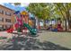 Colorful community playground with slides and play structures nestled among mature trees for shade at 8825 Latrec Ave # 6308, Orlando, FL 32819