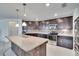 Spacious kitchen featuring dark wood cabinets, stainless steel appliances, and a mosaic backsplash at 139 Sunfish Dr, Winter Haven, FL 33881