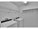 Laundry room with white washer, white dryer and wire shelving at 139 Sunfish Dr, Winter Haven, FL 33881