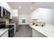 Kitchen with stainless steel appliances, granite counters, and grey wood-look flooring at 13434 Leaping Water Way, Astatula, FL 34705