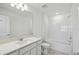 Bright bathroom with quartz countertops and tiled tub at 276 Woodsage Pl, Lake Alfred, FL 33850