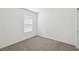 Empty bedroom with neutral walls, plush carpeting, and a large window, ready for personalization at 276 Woodsage Pl, Lake Alfred, FL 33850