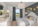 A cozy bedroom with a moon and stars accent wall, a dresser, and view from a large window at 276 Woodsage Pl, Lake Alfred, FL 33850