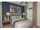 A beautifully decorated bedroom with a navy blue accent wall, large bed, and modern decor at 276 Woodsage Pl, Lake Alfred, FL 33850