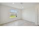 Bright, empty bedroom with a large window offering view of the backyard and neutral walls at 276 Woodsage Pl, Lake Alfred, FL 33850