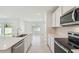 Bright kitchen boasts stainless steel appliances, white cabinets, and an island overlooking the backyard and dining area at 276 Woodsage Pl, Lake Alfred, FL 33850