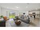 Bright, open-concept living room featuring modern furnishings, a stylish rug, and sliding glass doors to the backyard at 276 Woodsage Pl, Lake Alfred, FL 33850
