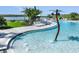 Inviting community pool area featuring a splash area, lounge chairs, and beautiful lake views at 280 Woodsage Pl, Lake Alfred, FL 33850