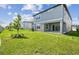 Large backyard showcasing lush green grass, white fence, and covered patio at 284 Woodsage Pl, Lake Alfred, FL 33850