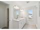 Bright bathroom features dual sinks, stone counters, and window lighting at 284 Woodsage Pl, Lake Alfred, FL 33850