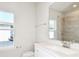 Bright bathroom featuring a quartz vanity and a tiled shower with glass door at 284 Woodsage Pl, Lake Alfred, FL 33850