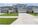 Two-story home with gray siding, lush lawn, and a concrete driveway leading to a two-car garage at 284 Woodsage Pl, Lake Alfred, FL 33850