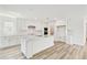 Spacious kitchen with white cabinets, stainless steel appliances, an island, and light wood flooring at 284 Woodsage Pl, Lake Alfred, FL 33850