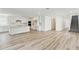 Open-concept living area showcasing wood flooring, a staircase, and seamless flow into the kitchen space at 284 Woodsage Pl, Lake Alfred, FL 33850