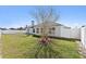 Backyard with well-kept lawn, white fence, and home featuring white trim windows at 524 Buckshot Ln, Lakeland, FL 33809