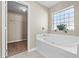 Bright bathroom showcasing a white tiled bathtub and view of the walk-in closet at 524 Buckshot Ln, Lakeland, FL 33809