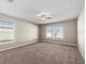 Spacious bedroom with carpet flooring, a ceiling fan, and natural light from two windows at 524 Buckshot Ln, Lakeland, FL 33809