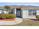 Inviting entrance with manicured flowerbeds, white door, and side windows for natural light at 524 Buckshot Ln, Lakeland, FL 33809