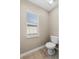 Powder room with toilet, window, and tile flooring at 524 Buckshot Ln, Lakeland, FL 33809