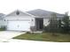 Charming one-story home featuring a two car garage, well-maintained lawn, and traditional design at 1371 Pompay Dr, Davenport, FL 33896